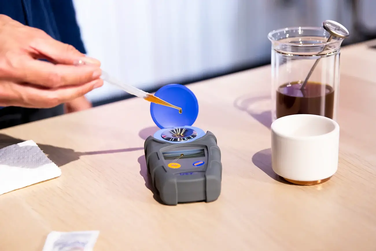 چکاندن نمونه قهوه روی رفرکتومتر دیجیتال برای اندازهگیری TDS